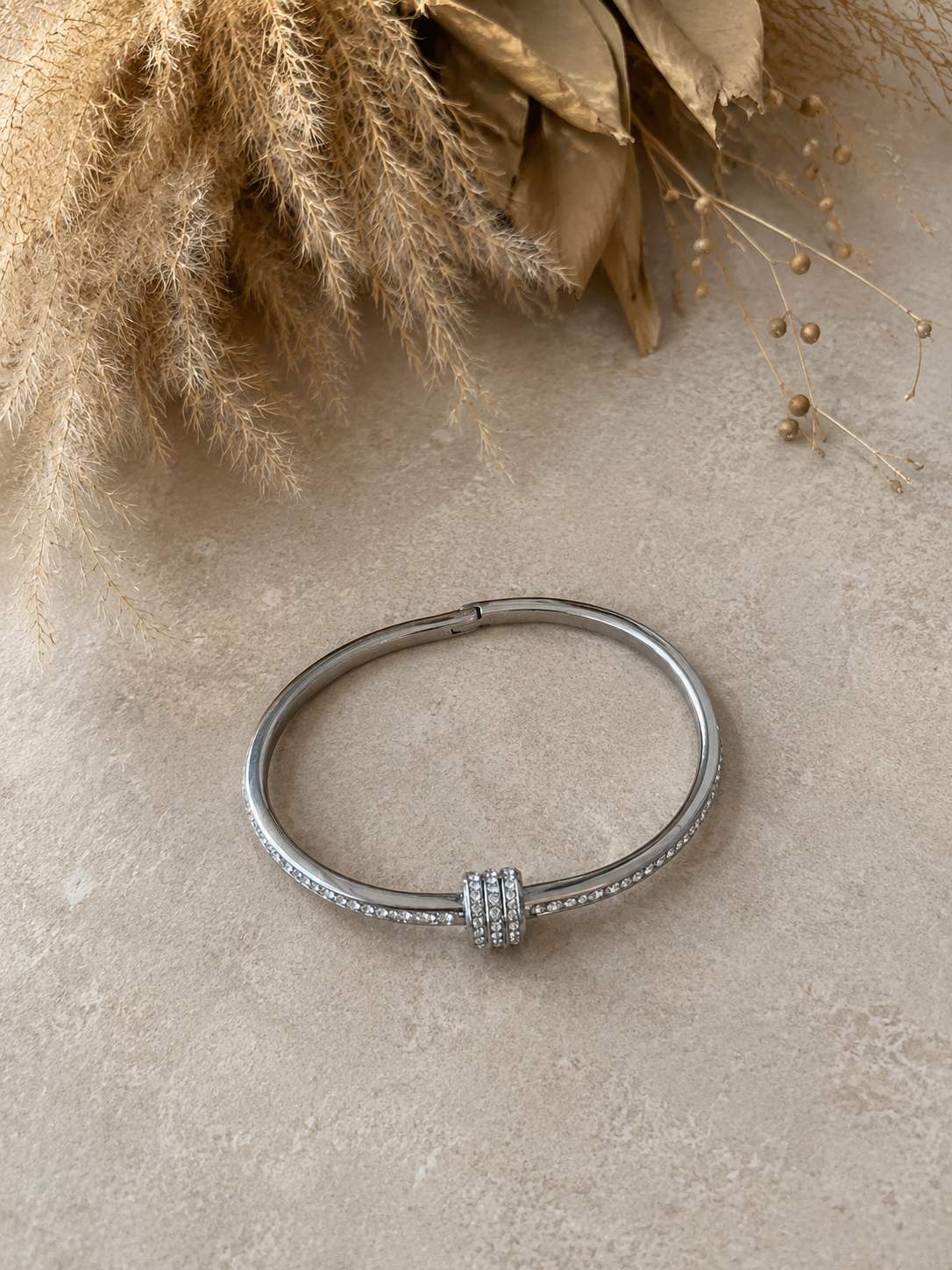 Pulsera plateada con punto de luz y detalle central