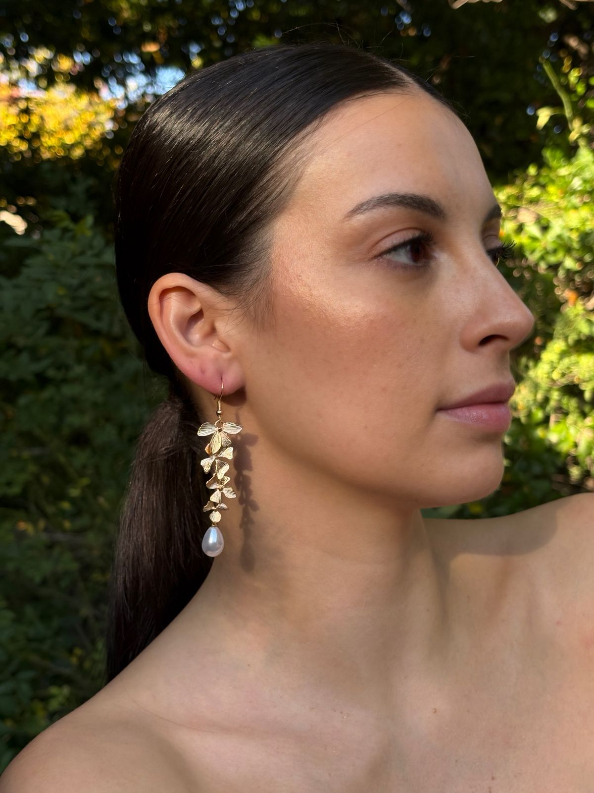 Aros colgantes en tono dorados con hojas y perlitas